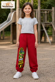 Mädchen trägt rote Jogginghose mit Stark mutig Dino-Print, von vorn auf dem Spielplatz.