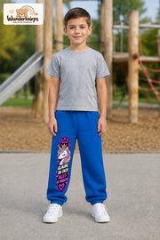 Junge trägt blaue Jogginghose mit Alles möglich Einhorn-Print, von vorn auf dem Spielplatz.