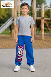 Junge trägt blaue Jogginghose mit Träume glitzern Einhorn-Print, von vorn auf dem Spielplatz.