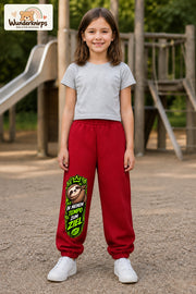 Mädchen trägt rote Jogginghose mit Mein Tempo Faultier-Print, von vorn auf dem Spielplatz.