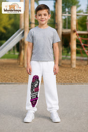 Junge trägt weiße Jogginghose mit Schönheit ohne Perfektion-Print, von vorn auf dem Spielplatz.