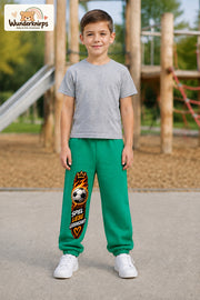 Junge trägt grüne Jogginghose mit Spiel Liebe Fußball-Print, von vorn auf dem Spielplatz.