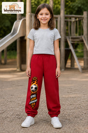 Mädchen trägt rote Jogginghose mit Spiel Liebe Fußball-Print, von vorn auf dem Spielplatz.