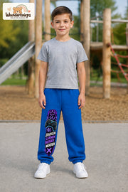 Junge trägt blaue Jogginghose mit Zocken Lernen Controller-Print, von vorn auf dem Spielplatz.