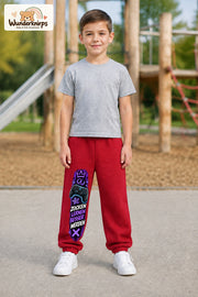 Junge trägt rote Jogginghose mit Zocken Lernen Controller-Print, von vorn auf dem Spielplatz.