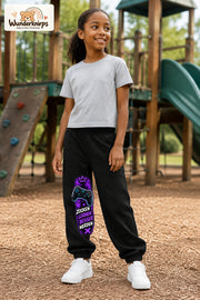 Mädchen trägt schwarze Jogginghose mit Gaming Sterne Violett-Print, leicht seitlich auf dem Spielplatz.