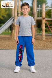 Junge trägt blaue Jogginghose mit Next Level Controller-Print, von vorn auf dem Spielplatz.