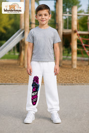 Junge trägt weiße Jogginghose mit Next Level Controller-Print, von vorn auf dem Spielplatz.