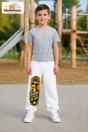 Junge trägt weiße Jogginghose mit Neugierig Giraffe-Print, von vorn auf dem Spielplatz.