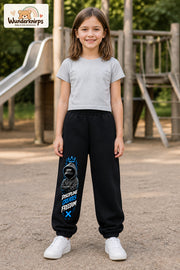Mädchen trägt schwarze Jogginghose mit Discipline Hoodie-Print, von vorn auf dem Spielplatz.