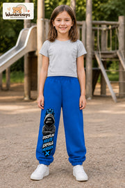 Mädchen trägt blaue Jogginghose mit Disziplin heute Hoodie-Print, von vorn auf dem Spielplatz.