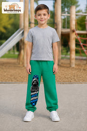 Junge trägt grüne Jogginghose mit Disziplin heute Hoodie-Print, von vorn auf dem Spielplatz.