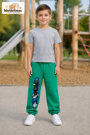 Junge trägt grüne Jogginghose mit No Limits Hoodie-Print, von vorn auf dem Spielplatz.