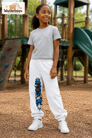 Mädchen trägt weiße Jogginghose mit No Limits Hoodie-Print, leicht seitlich auf dem Spielplatz.