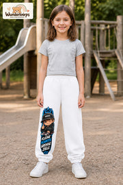 Mädchen trägt weiße Jogginghose mit Kleine Schritte Skater-Print, von vorn auf dem Spielplatz.