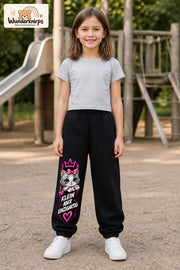 Mädchen trägt schwarze Jogginghose mit Klein einzigartig Katze-Print, von vorn auf dem Spielplatz.