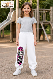 Mädchen trägt weiße Jogginghose mit Klein einzigartig Katze-Print, von vorn auf dem Spielplatz.