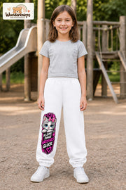 Mädchen trägt weiße Jogginghose mit Großes Glück Schleifenkatze-Print, von vorn auf dem Spielplatz.