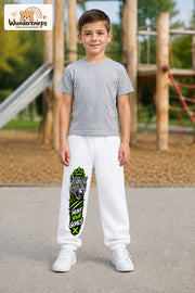 Junge trägt weiße Jogginghose mit Hunt Your Goals Leopard-Print, von vorn auf dem Spielplatz.