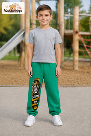 Junge trägt grüne Jogginghose mit Stärke von innen Löwe-Print, von vorn auf dem Spielplatz.