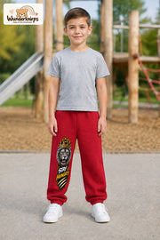 Junge trägt rote Jogginghose mit Stay Hungry Löwe-Print, von vorn auf dem Spielplatz.