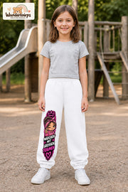 Mädchen trägt weiße Jogginghose mit Große Träume Bandana-Print, von vorn auf dem Spielplatz.