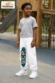 Junge trägt weiße Jogginghose mit Coole Kids Panda-Print, leicht seitlich auf dem Spielplatz.