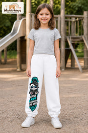 Mädchen trägt weiße Jogginghose mit Coole Kids Panda-Print, von vorn auf dem Spielplatz.
