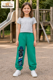Mädchen trägt grüne Jogginghose mit Beast Mode Panther-Print, von vorn auf dem Spielplatz.