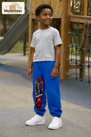 Junge trägt blaue Jogginghose mit Disziplin Samurai-Print, leicht seitlich auf dem Spielplatz.