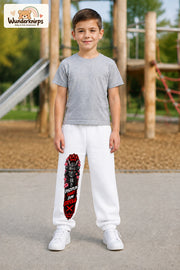 Junge trägt weiße Jogginghose mit Disziplin Samurai-Print, von vorn auf dem Spielplatz.