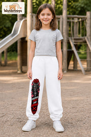 Mädchen trägt weiße Jogginghose mit Disziplin Samurai-Print, von vorn auf dem Spielplatz.