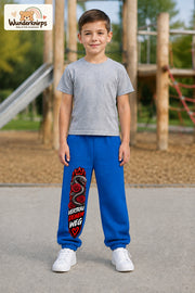 Junge trägt blaue Jogginghose mit Vertrau deinem Weg-Print, von vorn auf dem Spielplatz.