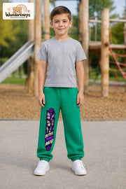 Junge trägt grüne Jogginghose mit Better Things Falter-Print, von vorn auf dem Spielplatz.