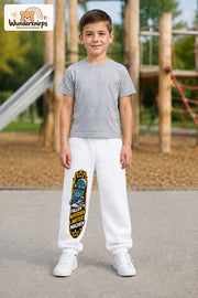 Junge trägt weiße Jogginghose mit Weitermachen Skateschuh-Print, von vorn auf dem Spielplatz.