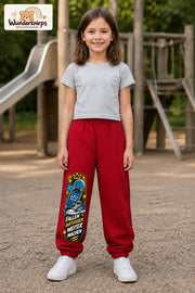 Mädchen trägt rote Jogginghose mit Weitermachen Sternen-Board-Print, von vorn auf dem Spielplatz.