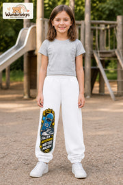 Mädchen trägt weiße Jogginghose mit Weitermachen Sternen-Board-Print, von vorn auf dem Spielplatz.