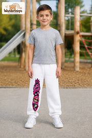 Junge trägt weiße Jogginghose mit Girl Boss Bär-Print, von vorn auf dem Spielplatz.