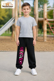 Junge trägt schwarze Jogginghose mit Girl Power Teddy-Print, von vorn auf dem Spielplatz.