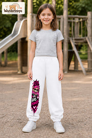 Mädchen trägt weiße Jogginghose mit Girl Power Teddy-Print, von vorn auf dem Spielplatz.