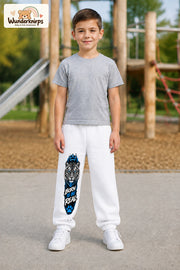 Junge trägt weiße Jogginghose mit Born to Be Real Tiger-Print, von vorn auf dem Spielplatz.