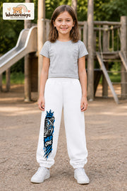 Mädchen trägt weiße Jogginghose mit Wild One Tiger-Print, von vorn auf dem Spielplatz.