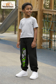 Junge trägt schwarze Jogginghose mit Be Brave Tiger-Print, leicht seitlich auf dem Spielplatz.