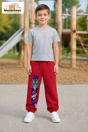 Junge trägt rote Jogginghose mit Wild but Loyal Tiger-Print, von vorn auf dem Spielplatz.