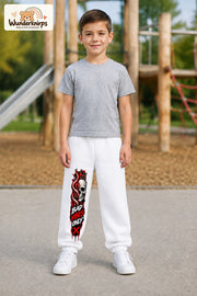 Junge trägt weiße Jogginghose mit Bad Vibes Skull-Print, von vorn auf dem Spielplatz.