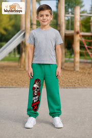 Junge trägt grüne Jogginghose mit Dead but Legendary-Print, von vorn auf dem Spielplatz.