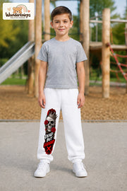 Junge trägt weiße Jogginghose mit Dead but Legendary-Print, von vorn auf dem Spielplatz.