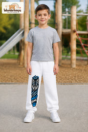 Junge trägt weiße Jogginghose mit Wild Soul Wolf-Print, von vorn auf dem Spielplatz.