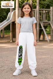 Mädchen trägt weiße Jogginghose mit Always Ahead Wolf-Print, von vorn auf dem Spielplatz.