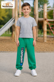 Junge trägt grüne Jogginghose mit Wunderknirps Graffiti-Print, von vorn auf dem Spielplatz.